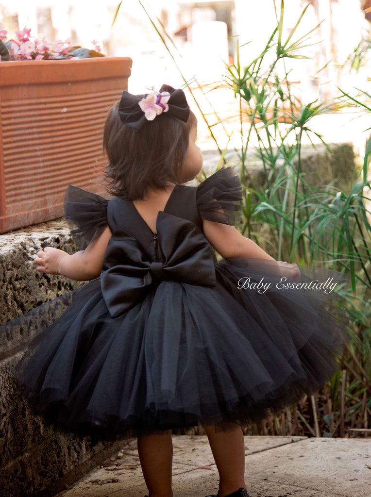 Black tulle tutu dress with big floral bouquet and big bow on the back.  Matching headpiece included