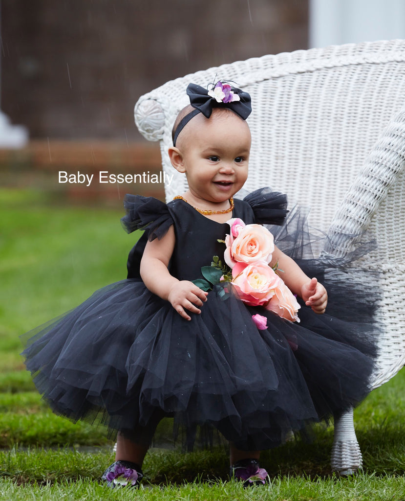 Black tulle tutu dress with big floral bouquet and big bow on the back.  Matching headpiece included.  Short plunging neck line.