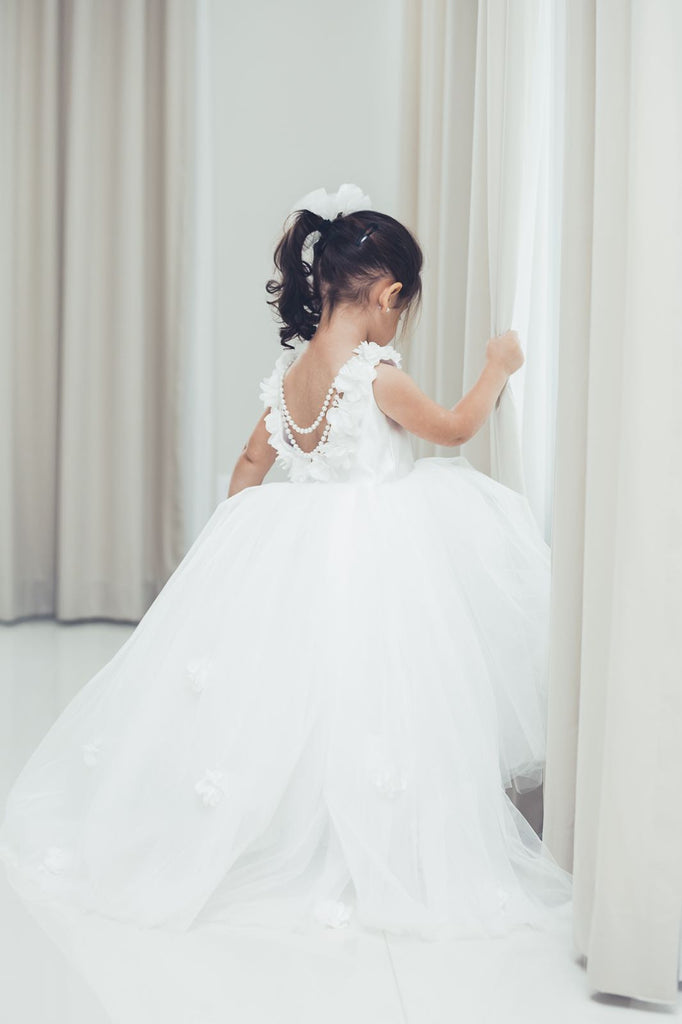 White dress, back view, white floral appliques, head bow shown