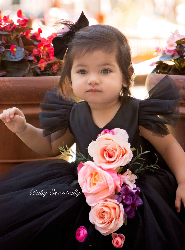 Black tulle tutu dress with big floral bouquet and big bow on the back.  Matching headpiece included.  Short plunging neck line.
