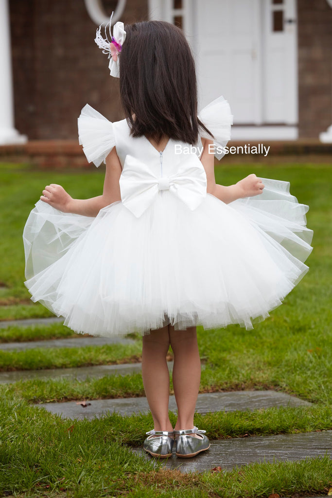 White tulle tutu dress with big floral bouquet. Matching headpiece included